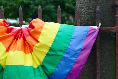 Close-up of pride flag hanging on fence