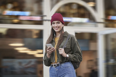 Smiling woman standing in front of building