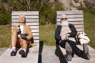 Couple relaxing on sun loungers