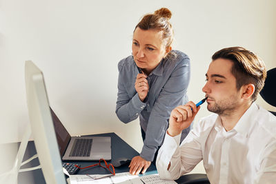 Business people discussing data on computer screen. employees coworkers working in office. teamwork