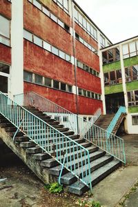 Empty bench by building against sky