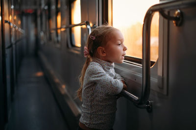 Rear view of boy sitting in train