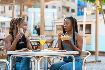 Portrait of a smiling young woman drinking glass at restaurant