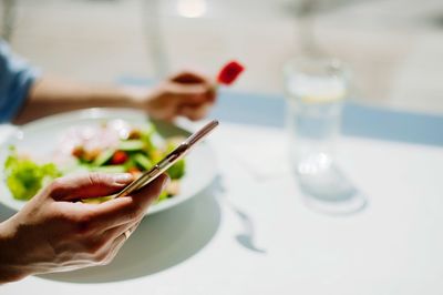 Close-up of hand holding ice cream on table