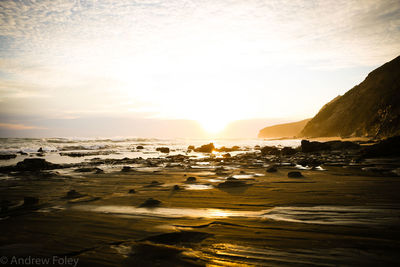 Scenic view of beach against sky during sunset