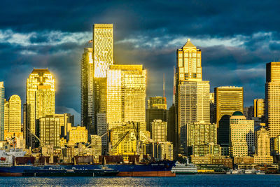 The setting sun makes a section of the city of seattle shine across elliott bay.