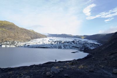 Scenic view of lake by mountains against sky