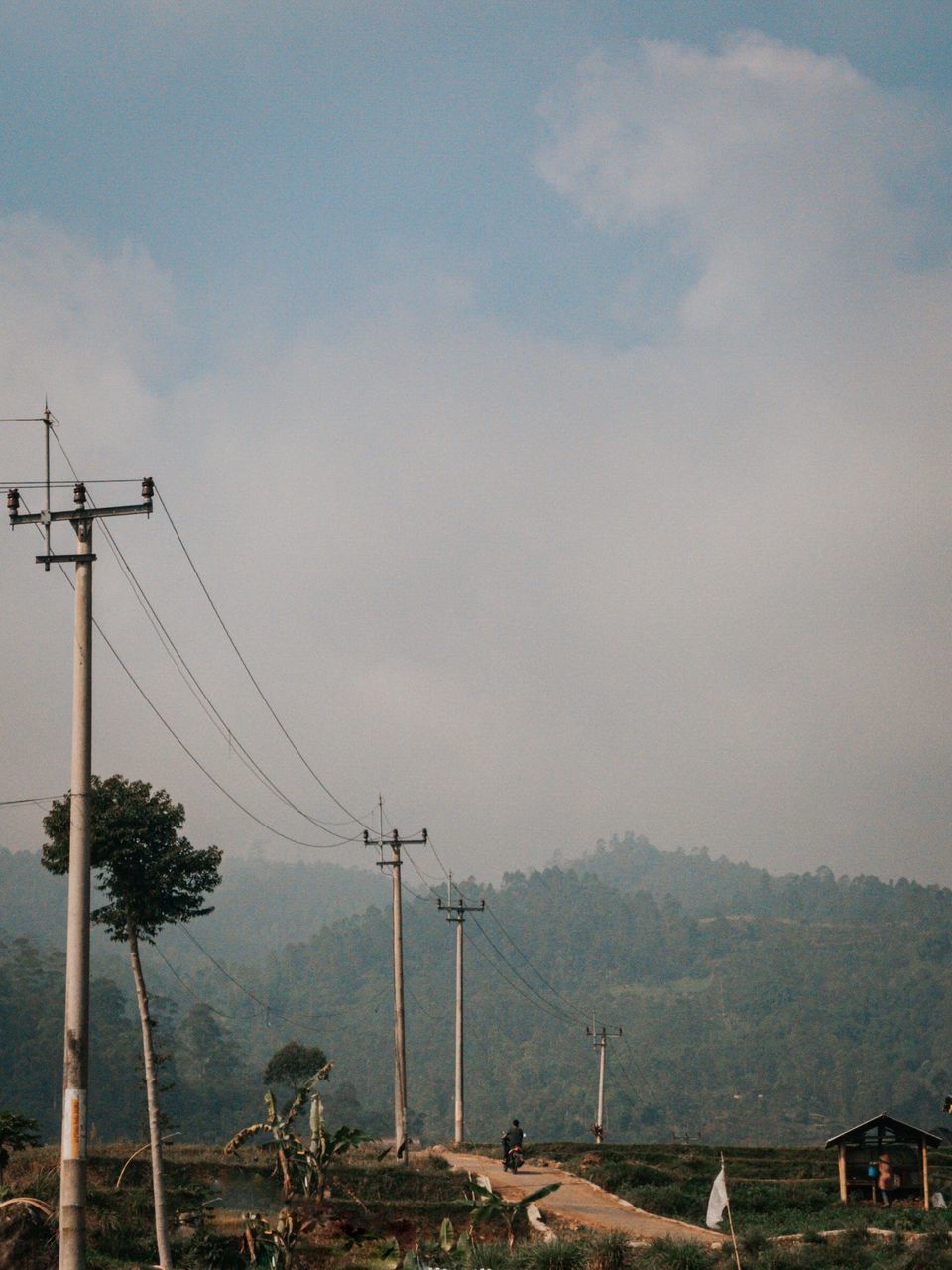 ELECTRICITY PYLON BY MOUNTAINS AGAINST SKY