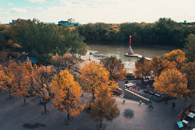 Trees in city against sky during autumn
