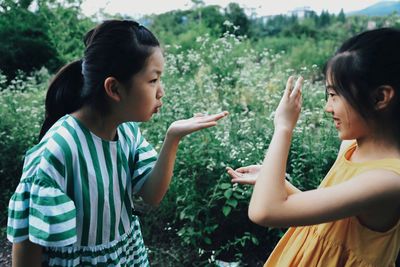 Girls playing by plants on field