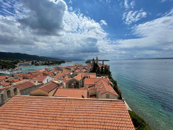 High angle view of buildings by sea against sky