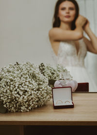 Wedding bouquet and rings in a box on the table.