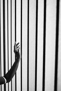 Human hand on railing against wall