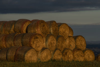 Hay bales on field against sky