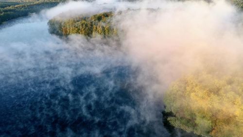 Scenic view of lake with fog in the morning 