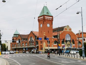 Group of people walking on road by buildings in city