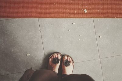 Low section of woman standing on tiled floor