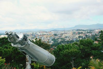 Binoculars at observation point against city