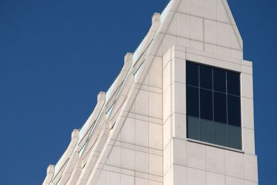 Low angle view of modern building against clear blue sky