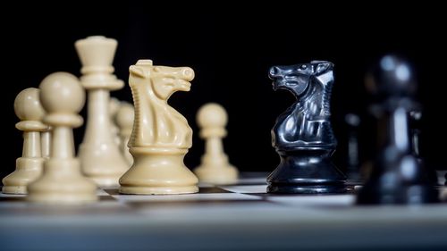 Close-up of chess board on table against black background