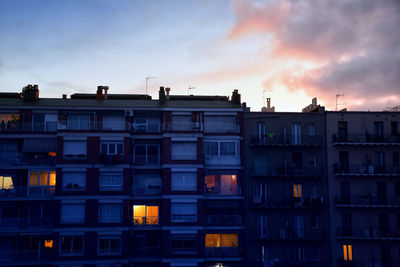 Residential buildings against sky at sunset