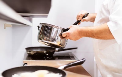 Midsection of man preparing food in kitchen