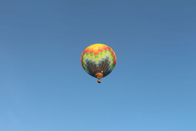 Low angle view of hot air balloon against clear blue sky