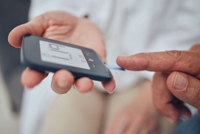 Midsection of man using mobile phone