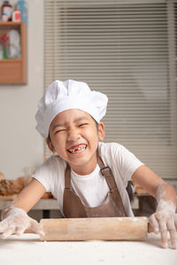 Portrait of cute boy smiling while sitting on table