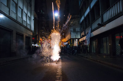 Firework display on street in city at night