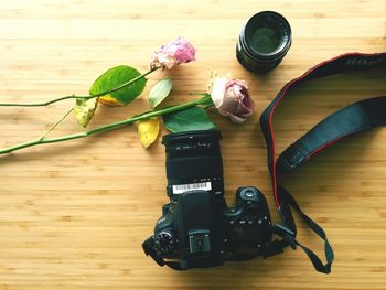 High angle view of camera with pink rose