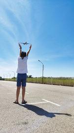 Forced perspective of a kid catching an airplane near an airport