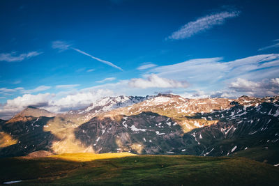 Aerial view of snowcapped mountains against blue sky