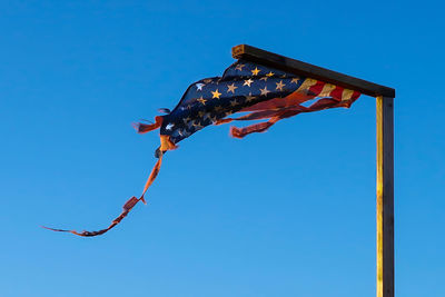 Low angle view of kites against clear blue sky