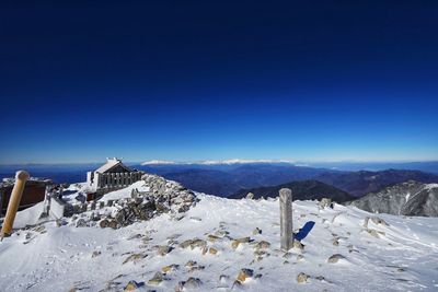 Scenic view of snowcapped mountains against clear blue sky