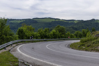 Road by mountain against sky