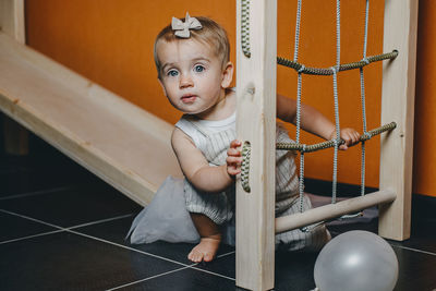 Active games for baby indoors activities. toddler girl play on home wooden indoor playsets. 