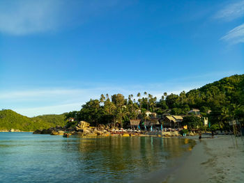Scenic view of lake and trees against blue sky