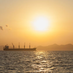 Silhouette ship in sea against sky during sunset