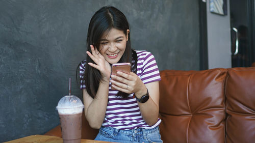 Happy young woman holding mobile phone