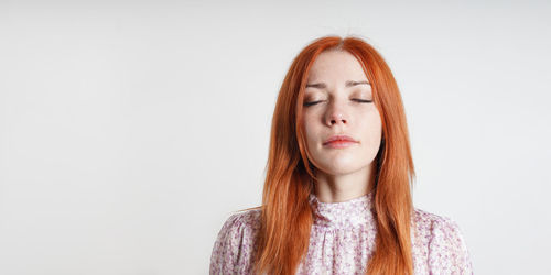 Portrait of young woman against white background