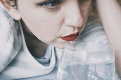 Close-up portrait of young woman drinking glass