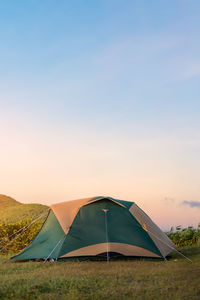 Tent on field against sky during sunset