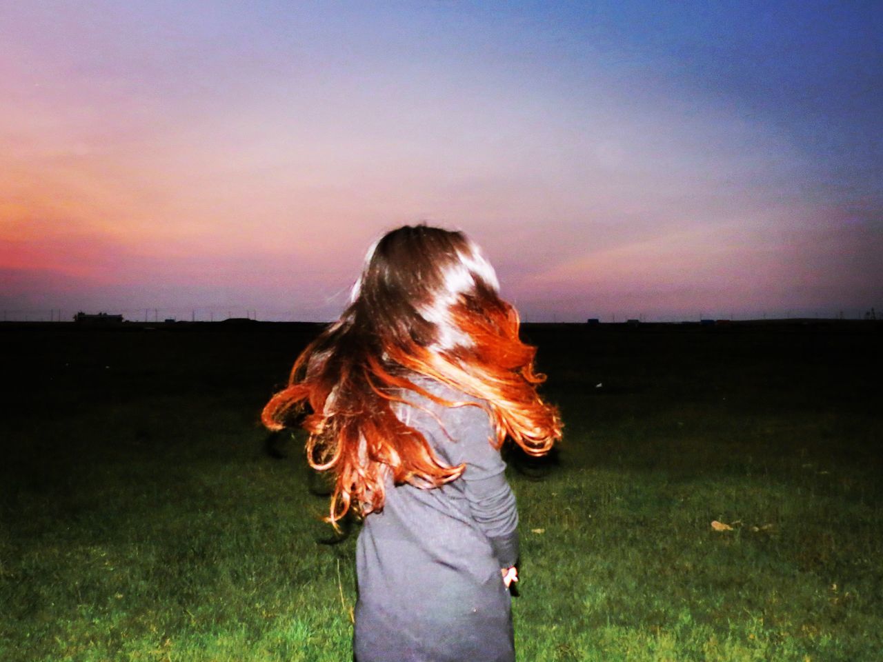 field, sky, hairstyle, land, hair, sunset, real people, one person, grass, long hair, women, environment, three quarter length, nature, landscape, plant, standing, lifestyles, leisure activity, outdoors, tousled hair, hair toss, human hair