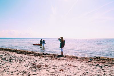 People at beach against sky