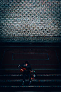 High angle view of woman sitting on bench