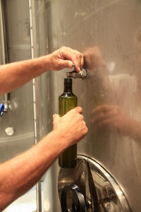 Close-up of man holding glass bottle