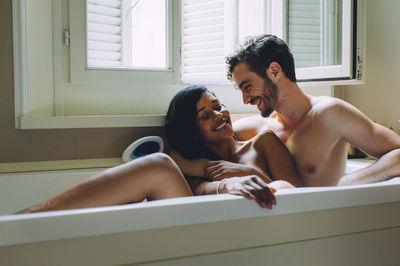 Happy couple sitting in bathroom