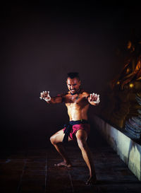 Portrait of shirtless man in darkroom