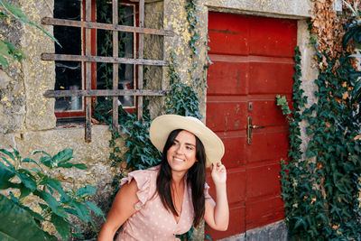 Portrait of a beautiful young woman in pink dress in idyllic old town, village, street.